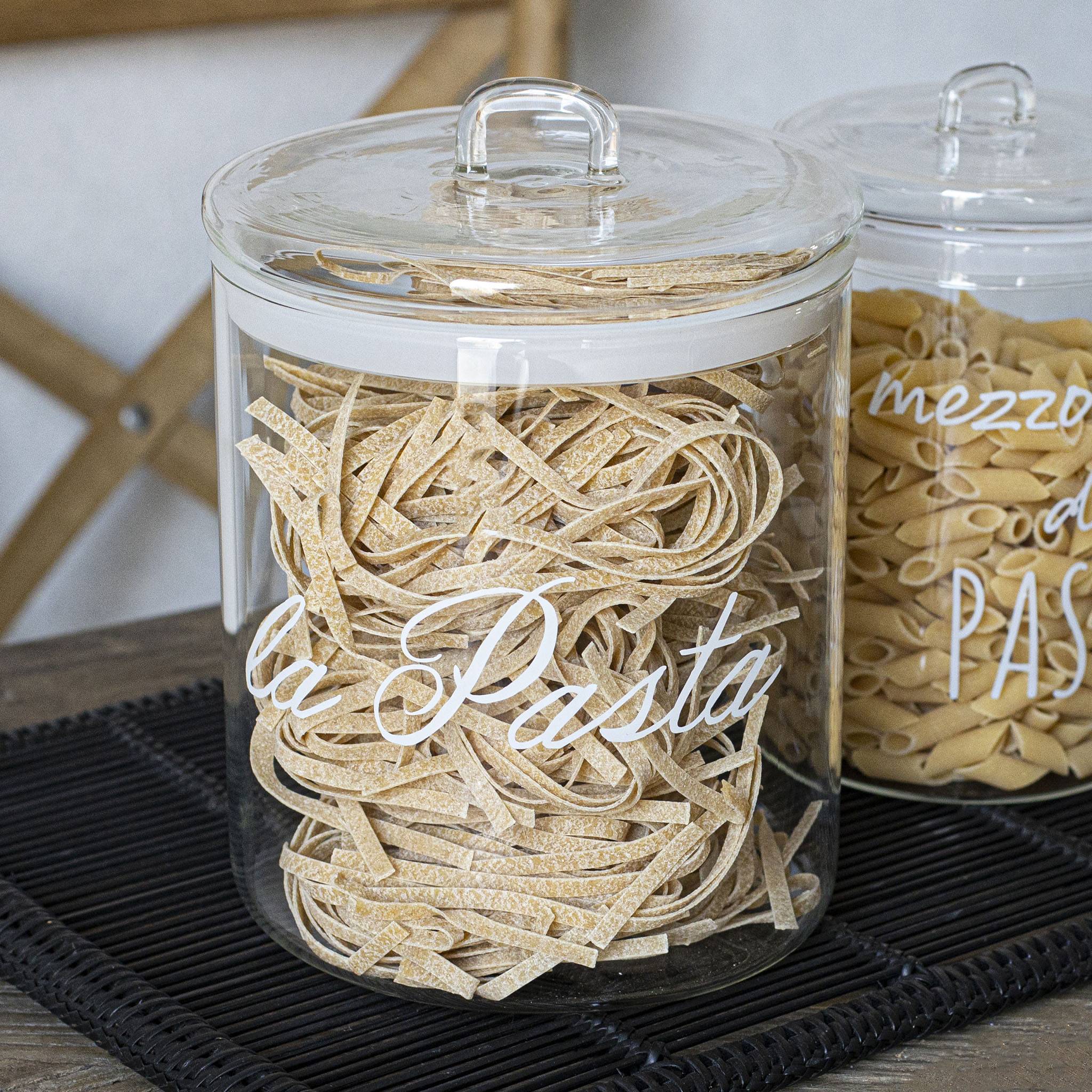 Una collezione di pasta in barattoli con sopra diversi tipi di pasta.